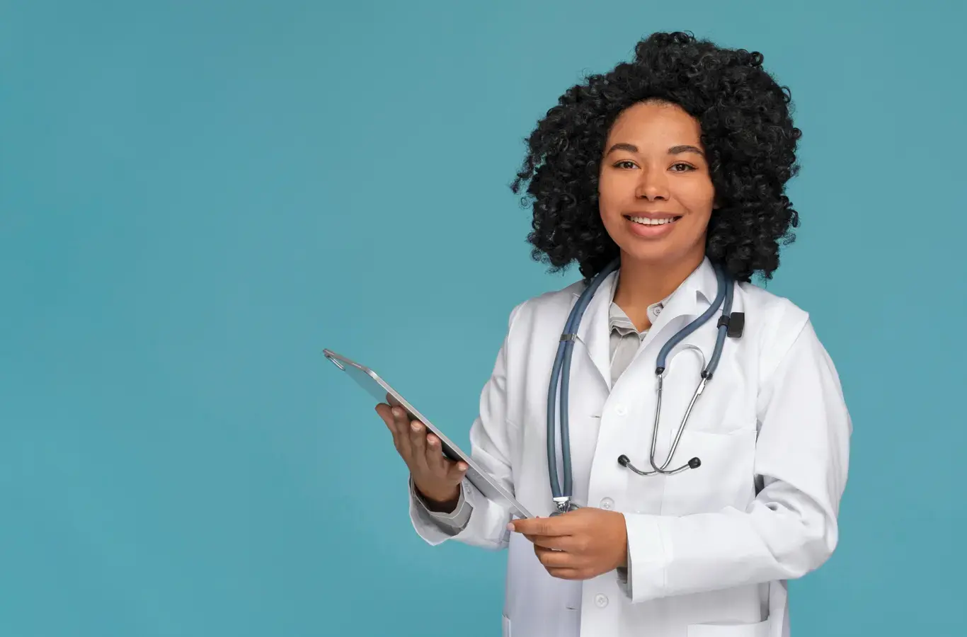 médica usando jaleco e segurando um tablet para ilustrar o conteúdo sobre como passar em medicina
