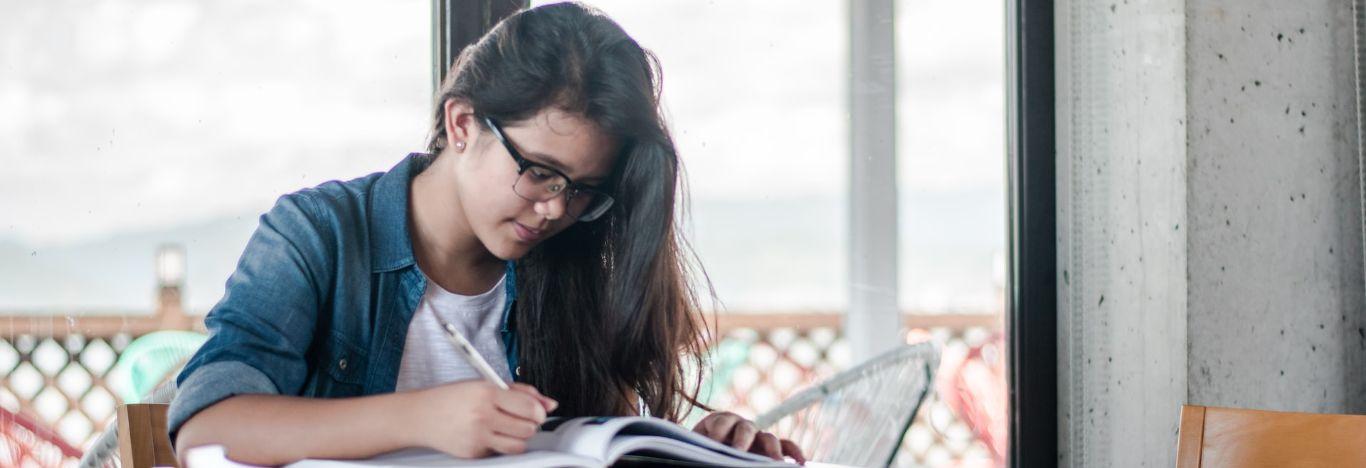 Menina usando óculos estudando sobre caatinga