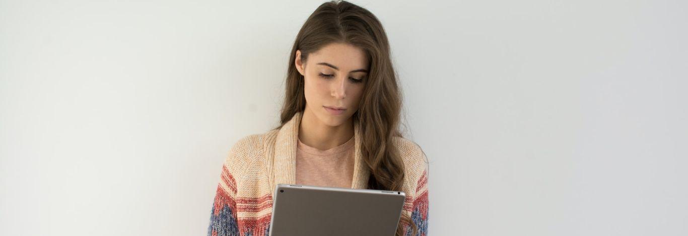 menina lendo um conteúdo sobre pronomes de tratamento em um tablet