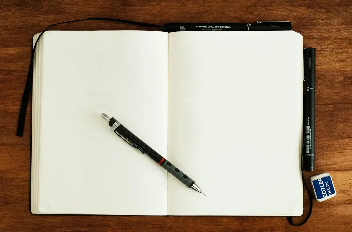 caderno aberto com uma lapiseira em cima para ilustrar o conteúdo de redação pronta sobre humor 