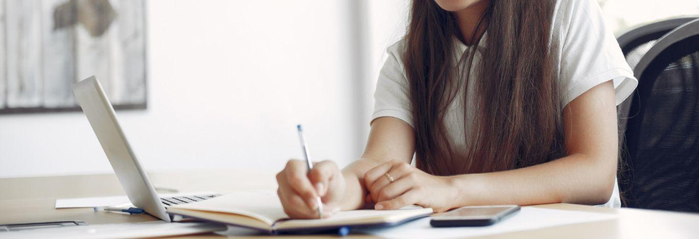 pessoa pesquisando e anotando como fazer a inscrição no fies