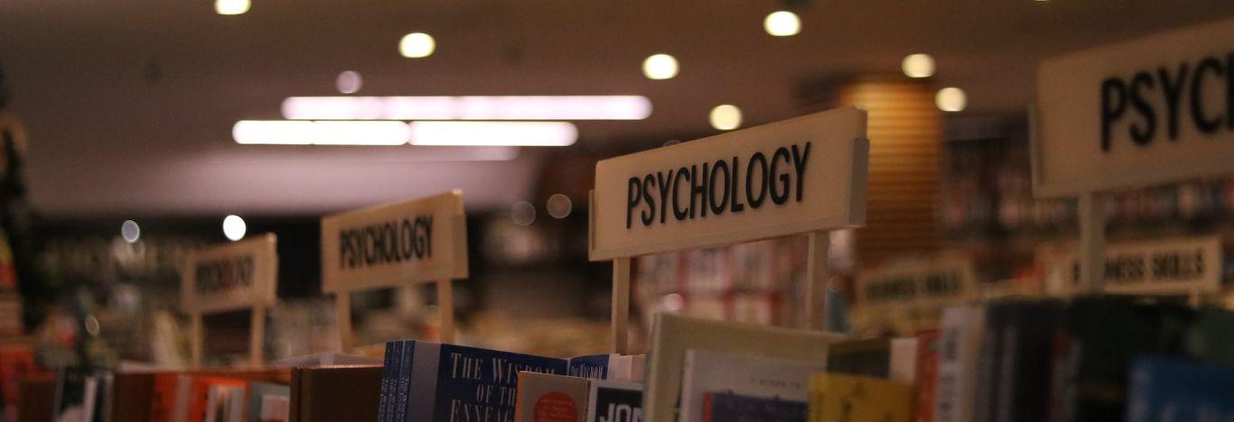 estante de livros de psicologia para ilustrar o conteúdo sobre como é a faculdade de psicologia