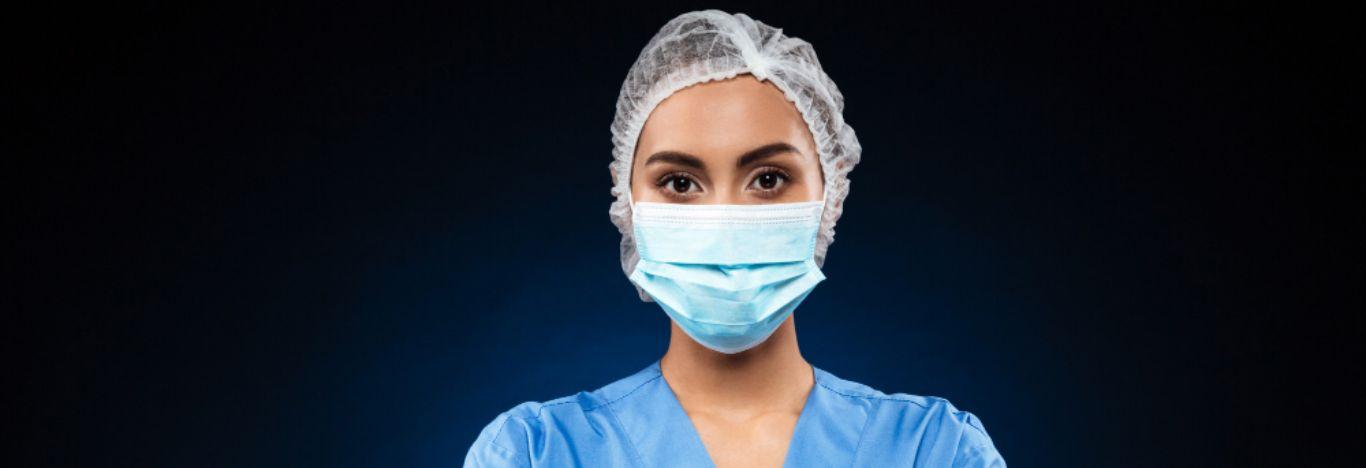mulher com touca e máscara se preparando para uma pós-graduação em enfermagem