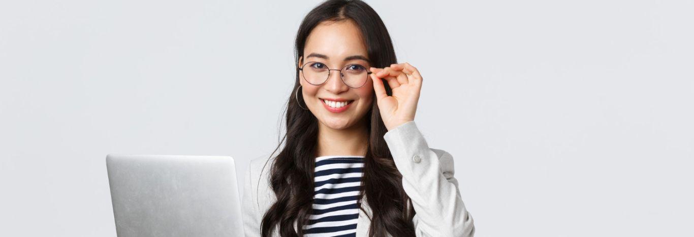 mulher segurando um notebook com uma mão e com a mão no óculos que está em seu rosto para ilustrar o conteúdo sobre pós-graduação em gestão de pessoas