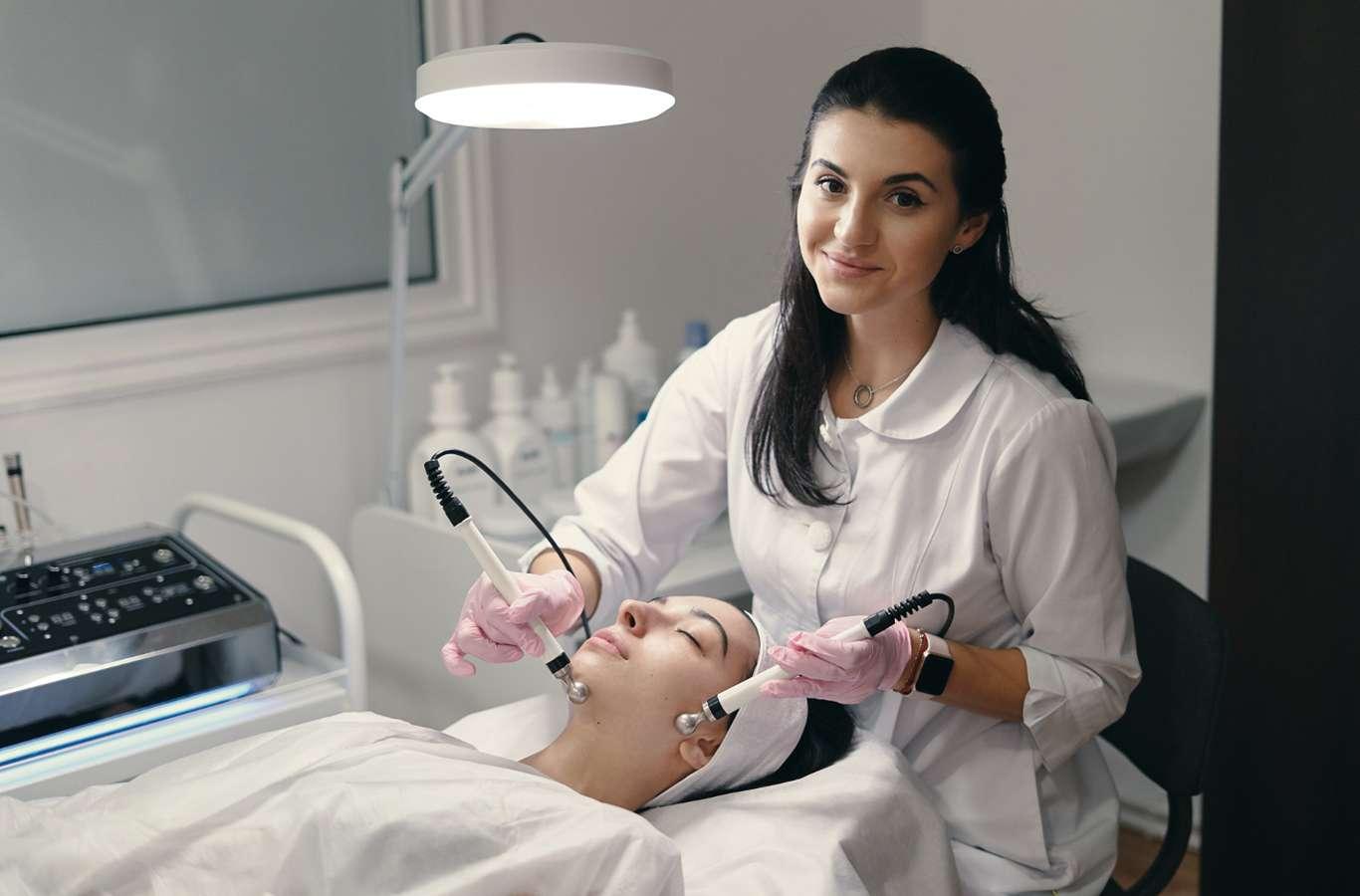 Esteticista fazendo procedimento no rosto de um paciente para ilustrar texto sobre pós-graduação para esteticistas