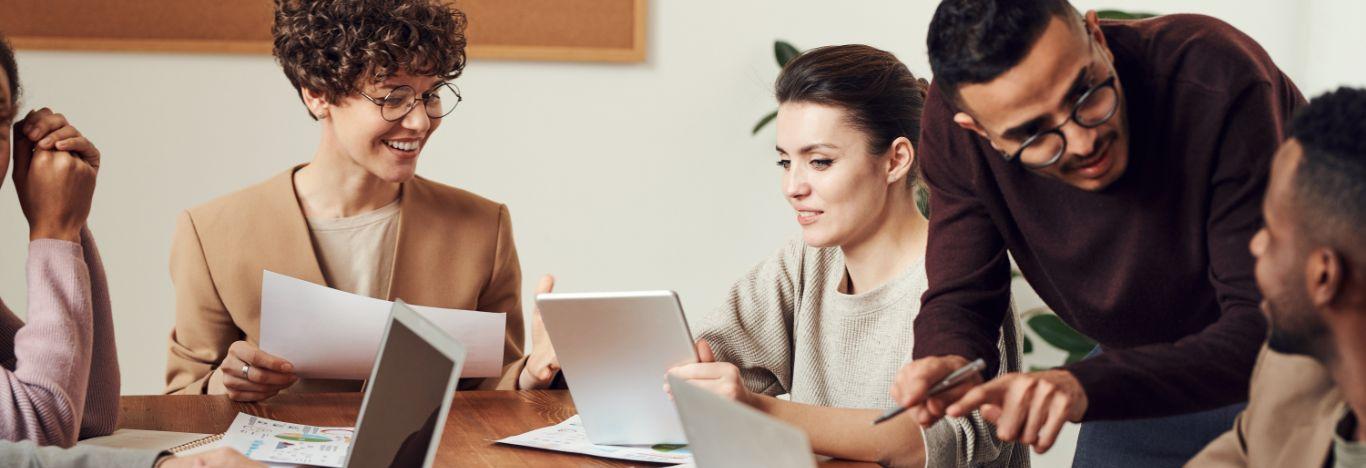 Pessoas em uma mesa de reunião para ilustrar artigo sobre metodologias ageis