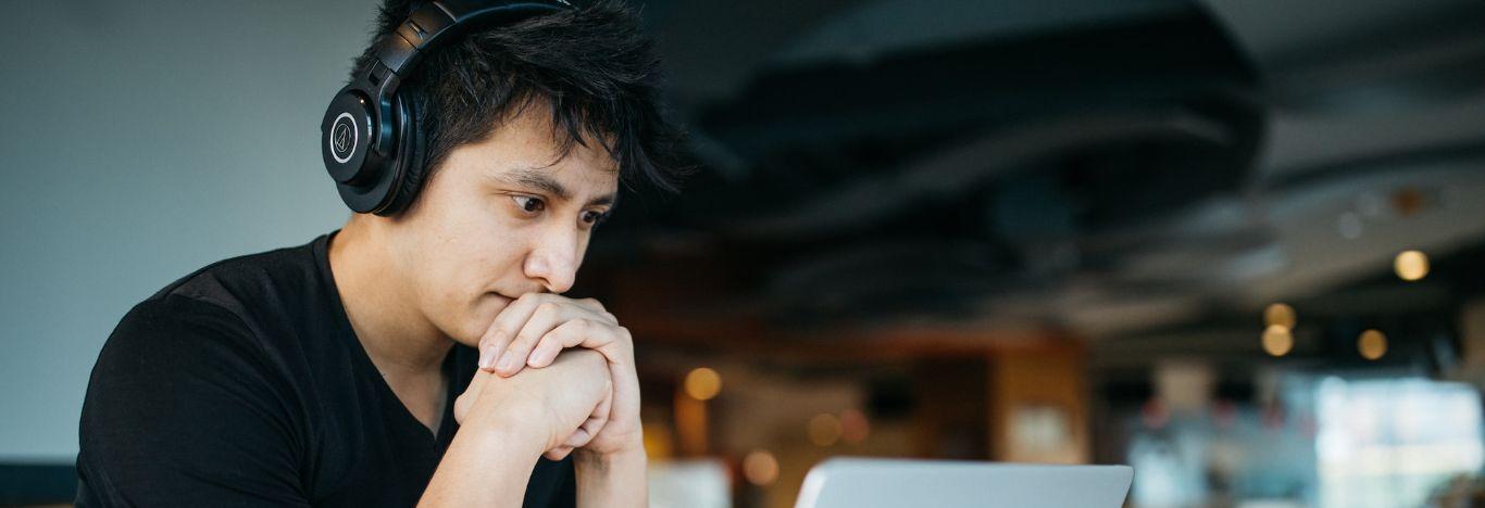 menino usando headset olhando para a tela de um notebook procurando como emitir o certificado de curso livre