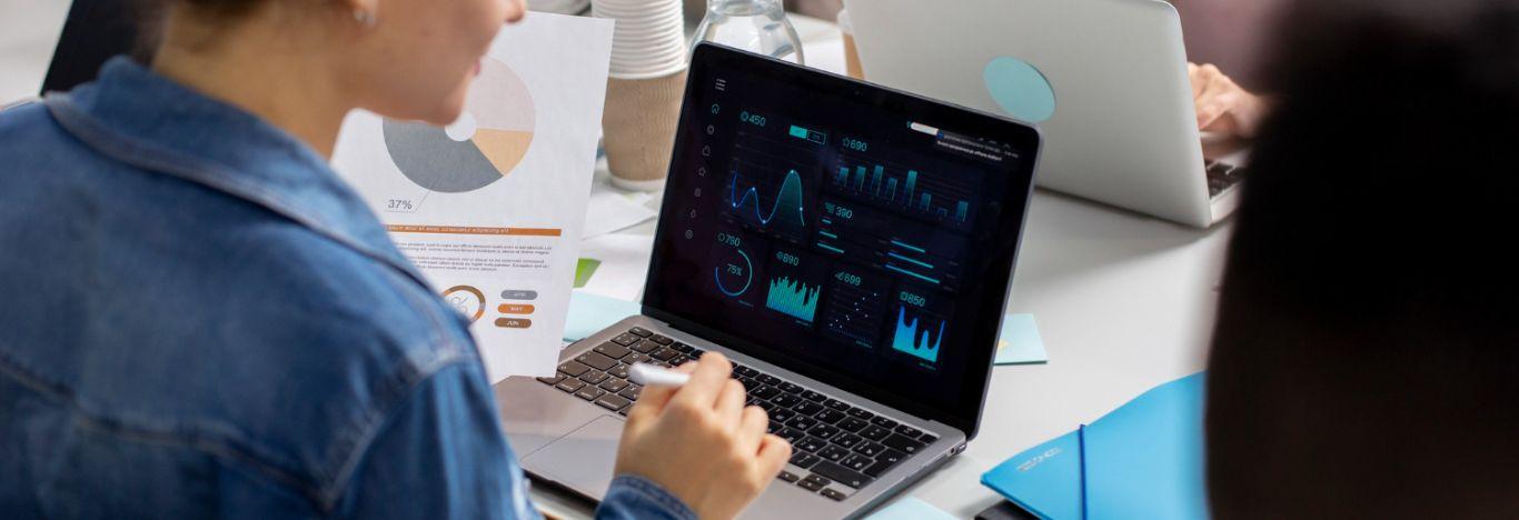 mulher com o notebook aberto para ilustrar o conteúdo sobre análise e desenvolvimento de sistemas grade curricular