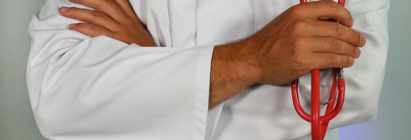 Imagem de um homem de jaleco branco, com estetoscópio em uma das mãos e braços cruzados para ilustrar artigo sobre note de corte no sisu para o curso de medicina