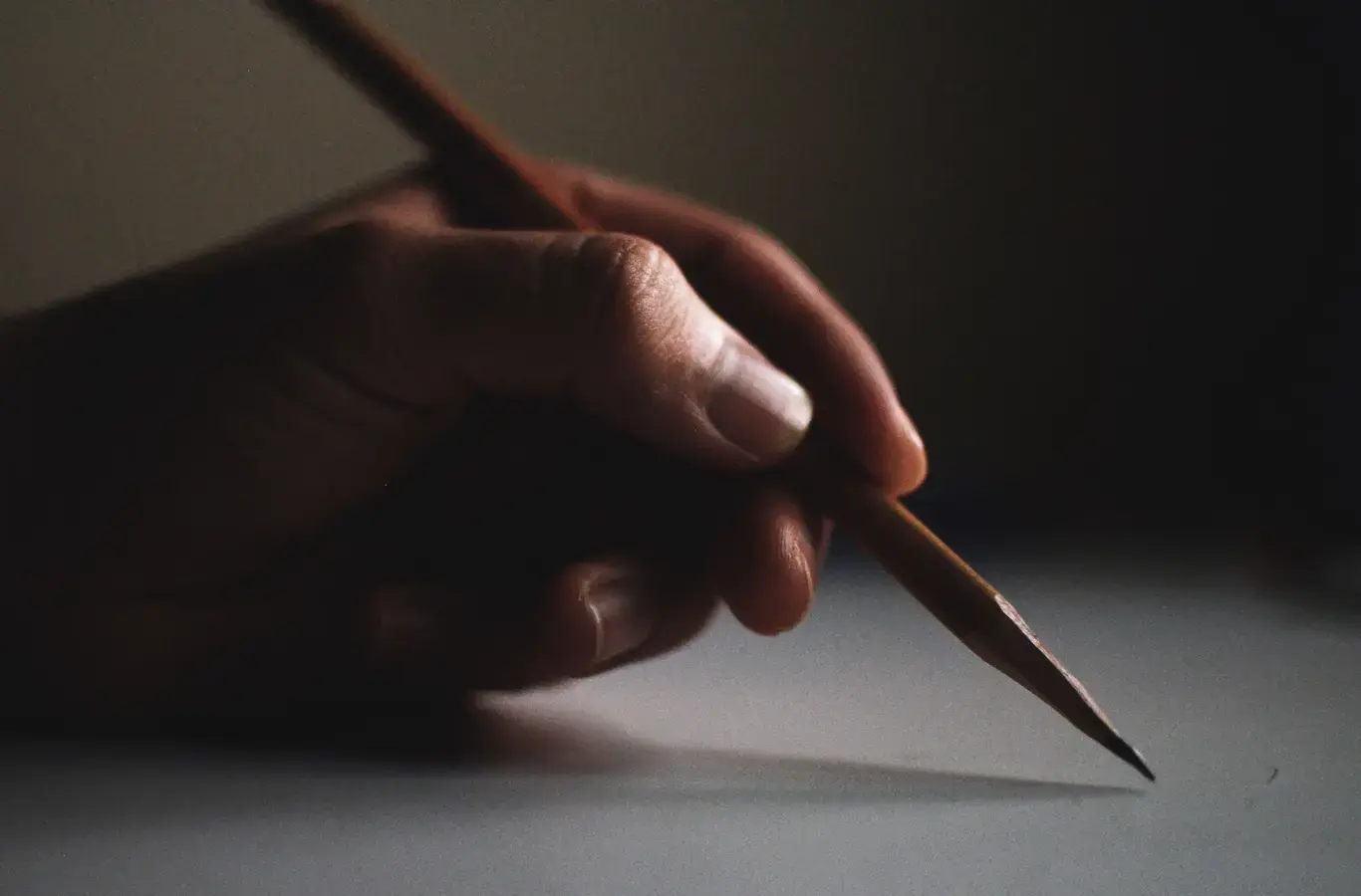 pessoa segurando um lápis para ilustrar o conteúdo sobre competências da redação do Enem