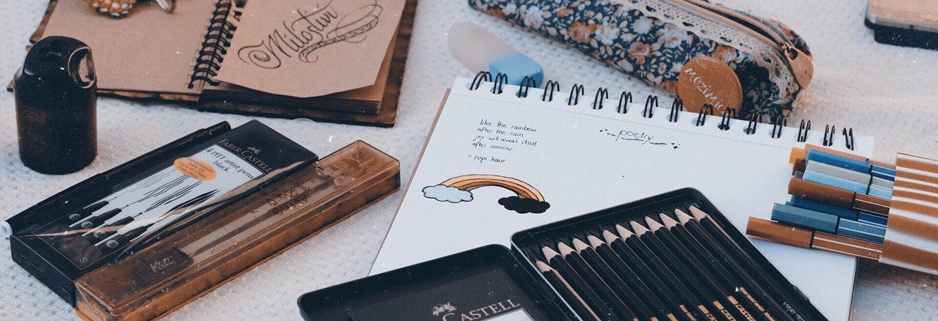 Estojo e outros materiais de faculdade em cima da mesa.