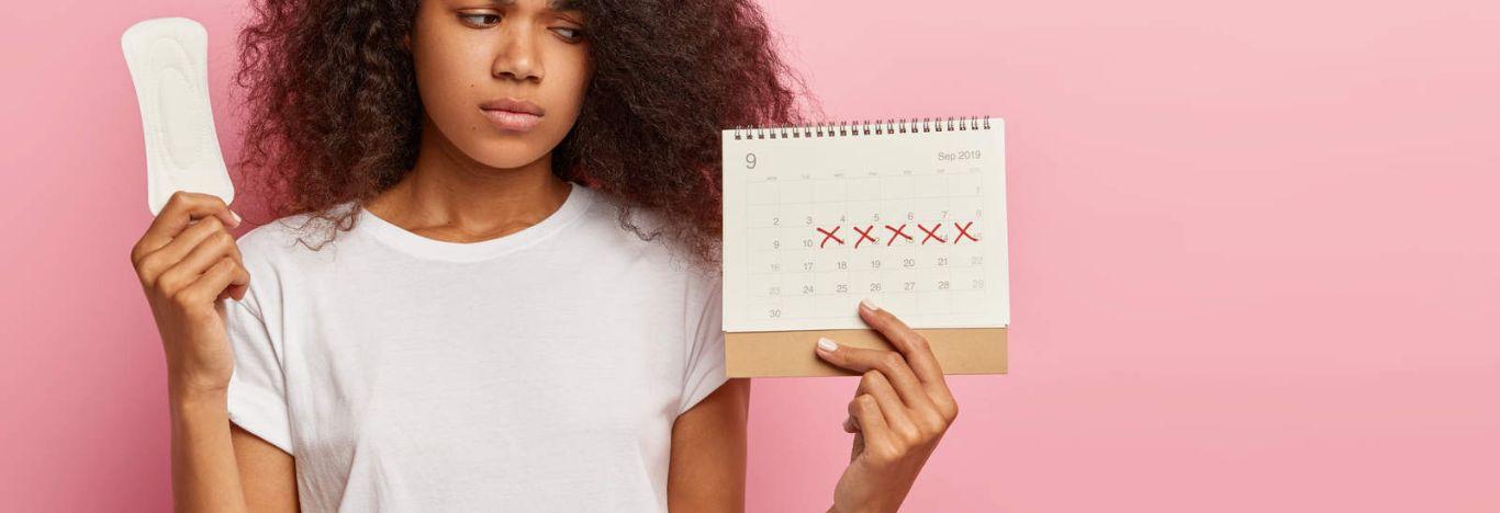 Mulher ilustrando o ciclo menstrual com um absorvente em uma mão e um calendário em outra.