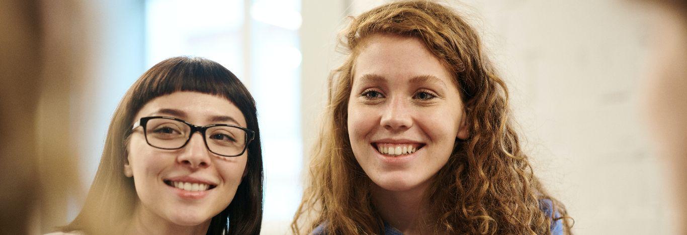 Duas mulheres sorrindo para ilustrar o conteúdo sobre pós-graduação em Gestão de Recursos Humanos.
