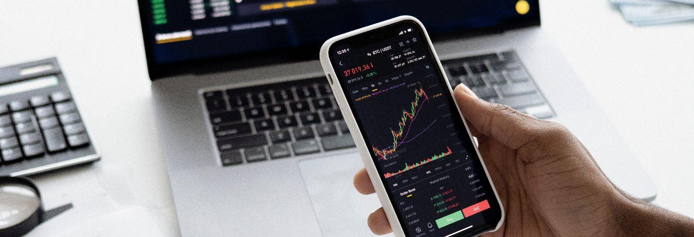 Celular mostrando um gráfico de ações para ilustrar o tema qual pós-graduação fazer em gestão financeira?